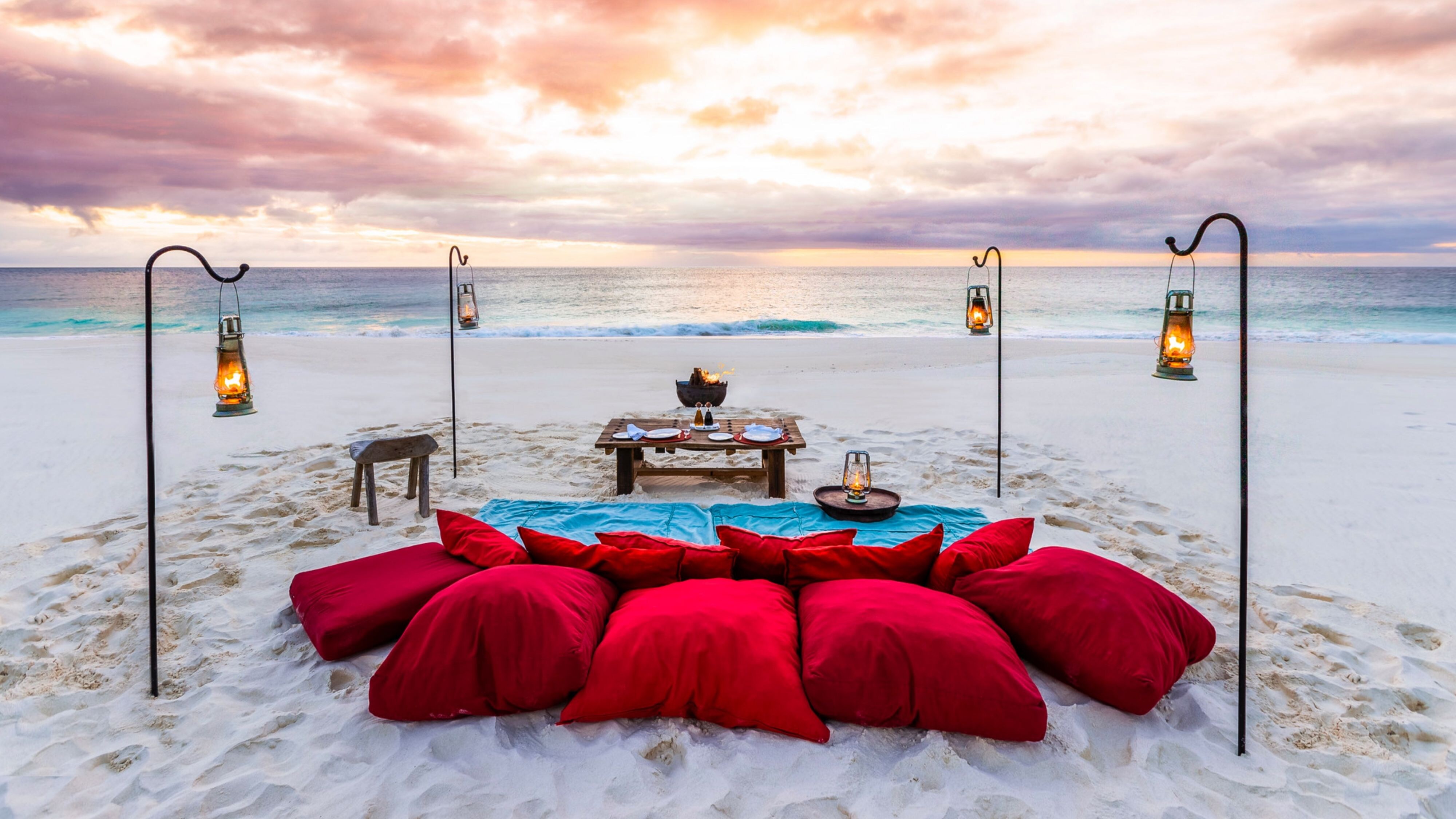 白色沙滩、海洋与火红的枕头图像