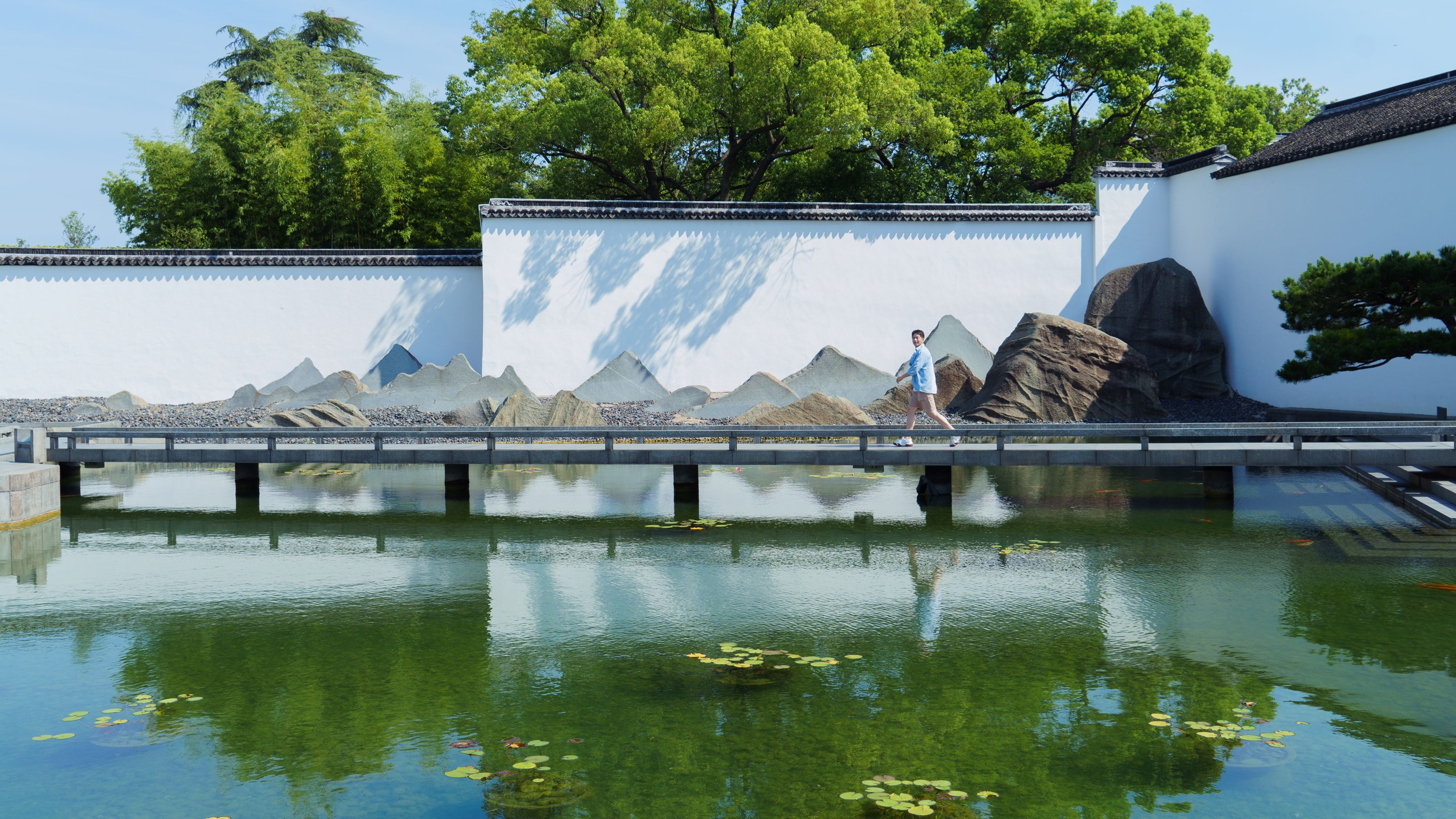 男生走在苏州花园桥上漫步