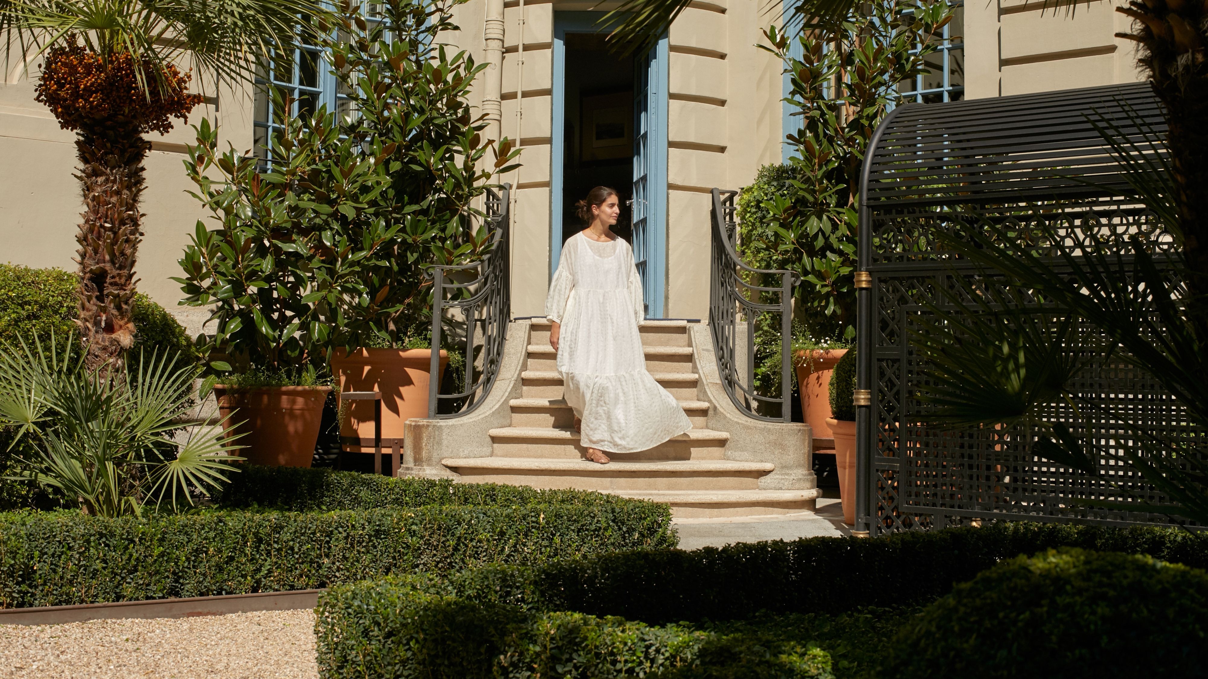 一个身穿白色晨袍的新娘站在豪华精选酒店的楼梯上