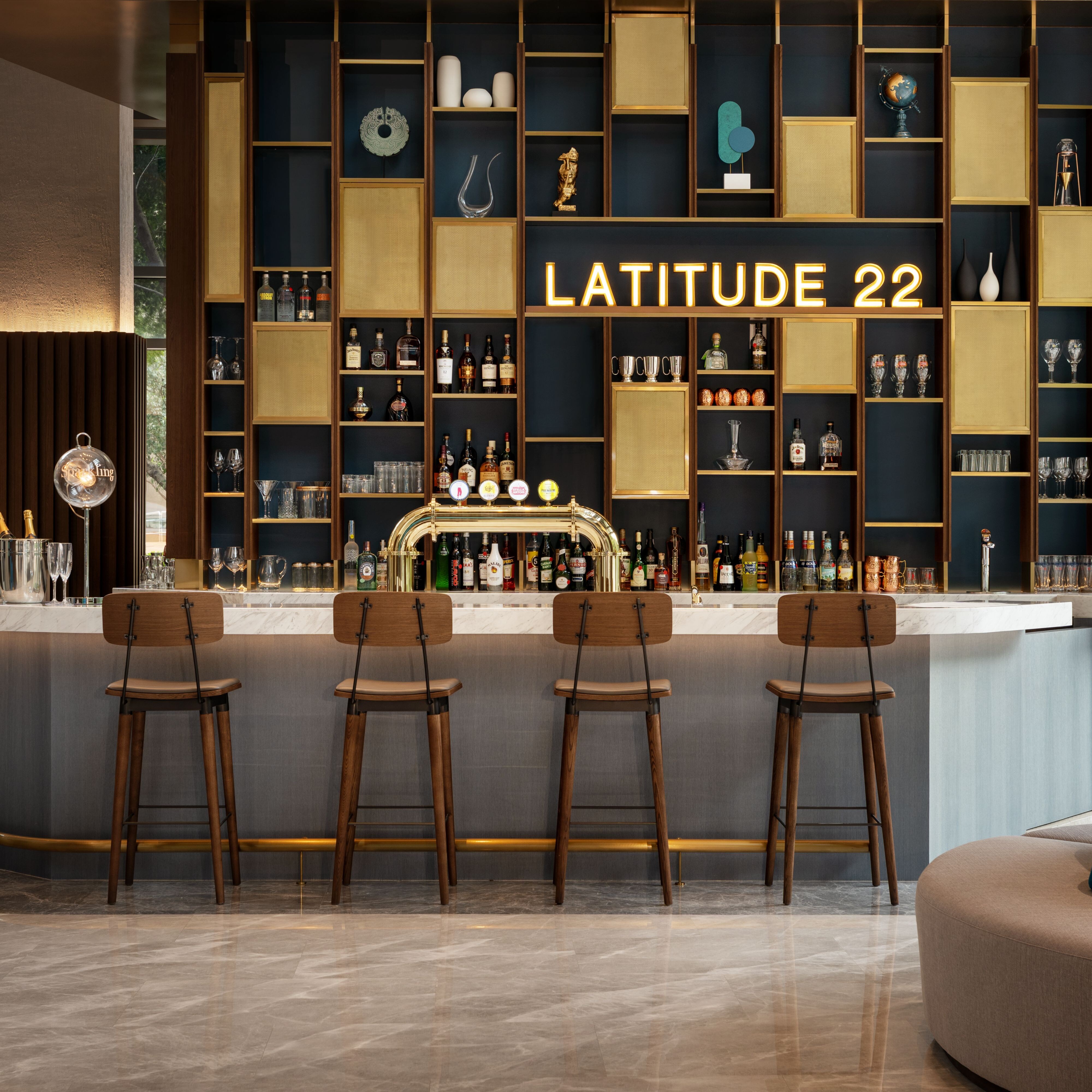 用餐区展现深色木质氛围，配有黄色和绿色的坐垫，以及高木椅的吧台