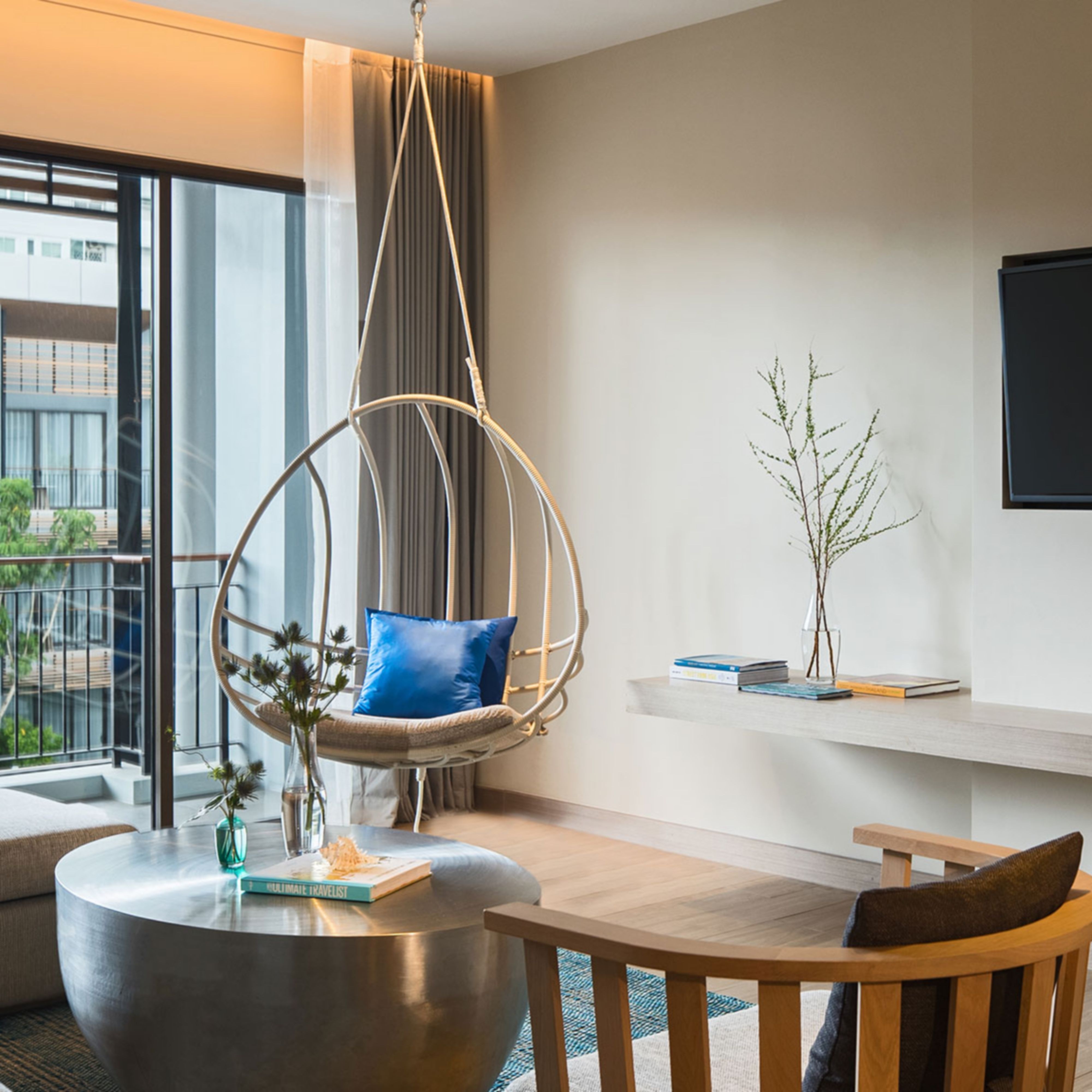 家庭套房起居室，配备电视和秋千，设有阳台