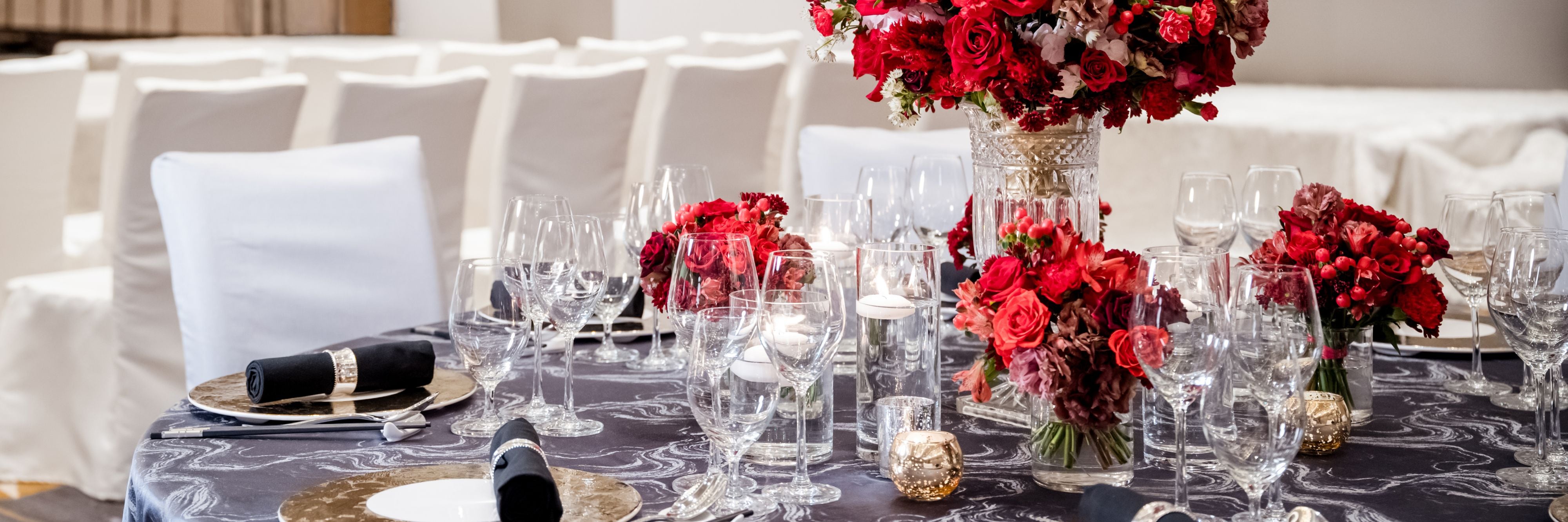 Wedding reception table with red flowers