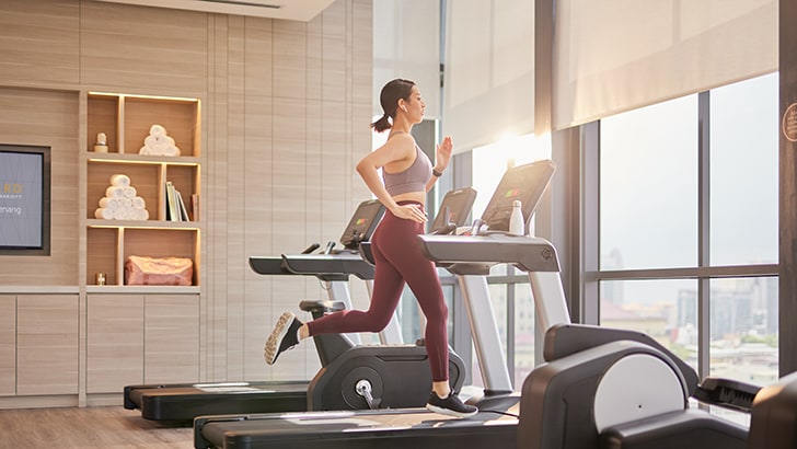 客人在健身房跑步机上慢跑