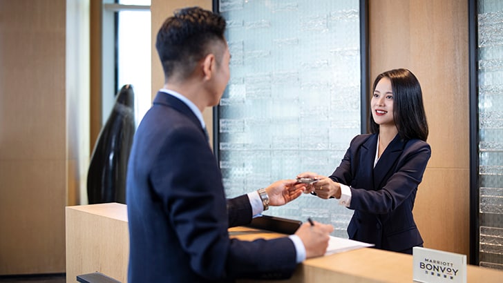 酒店接待员递给客人房间钥匙